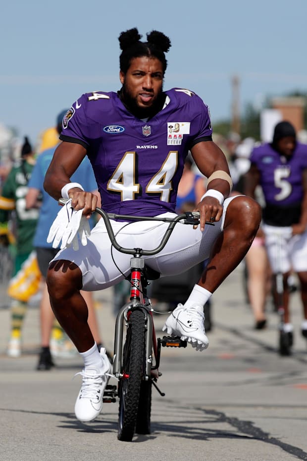 Baltimore Ravens cornerback Marlon Humphrey rides a young fan's bicycle to a joint practice with the Green Bay Packers .