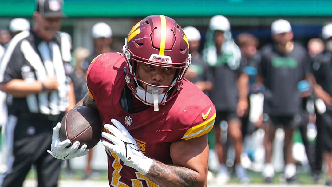 Aug 10, 2024; East Rutherford, New Jersey, USA; Washington Commanders running back Chris Rodriguez Jr. (23) carries the ball  during the first half against the New York Jets at MetLife Stadium. Mandatory Credit: Vincent Carchietta-Imagn Images