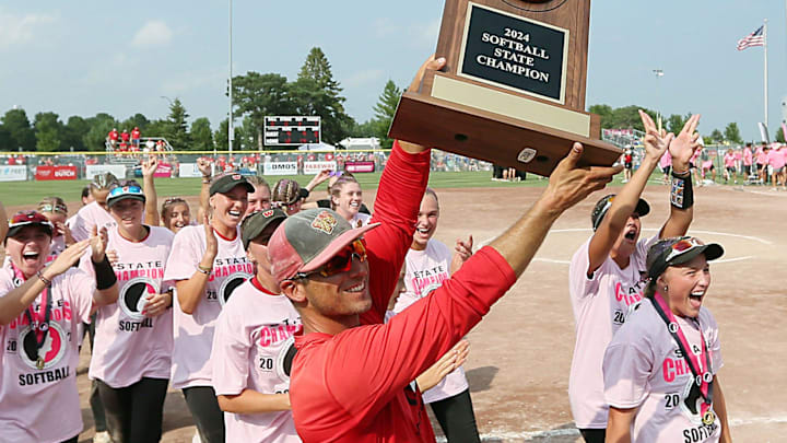 Williamsburg's coach Adam Berte holds the trophy as team celebrating after winning against Davenport Assumption in the 3A Iowa high school state softball tournament championship at Rogers Sports complex on Friday, July 26, 2024, in Fort Dodge, Iowa. Williamsburg's coach Adam Berte holds the trophy as team celebrating after winning against Davenport Assumption in the 3A Iowa high school state softball tournament championship at Rogers Sports complex on Friday, July 26, 2024, in Fort Dodge, Iowa.