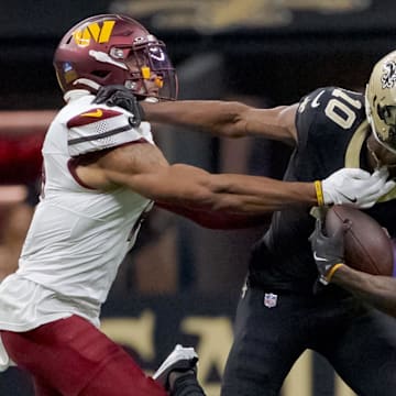 Dec 15, 2024; New Orleans, Louisiana, USA; New Orleans Saints wide receiver Marquez Valdes-Scantling (10) makes a reception against Washington Commanders safety Jeremy Chinn (11) during the second half both were slow getting up after the play after colliding with Washington Commanders safety Darrick Forrest (22) at Caesars Superdome. Mandatory Credit: Matthew Hinton-Imagn Images