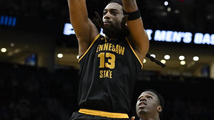 Mar 19, 2026; Portland, OR, USA; Kennesaw State Owls forward Braedan Lue (13) shoots against Gonzaga Bulldogs forward Emmanuel Innocenti (5) during the second half of a first round game of the men's 2026 NCAA Tournament at Moda Center. Mandatory Credit: Troy Wayrynen-Imagn Images