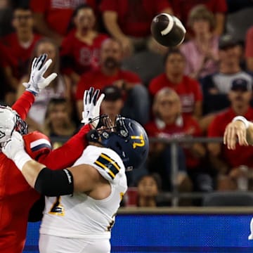 Sep 7, 2024; Tucson, Arizona, USA; Arizona Lumberjacks quarterback Ty Pennington (6) throws the ball against Arizona Wildcats defensive lineman Tre Smith (3) during first quarter at Arizona Stadium.