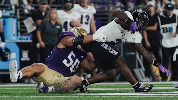 UW defensive tackle Sebastian Valdez pulls down Weber State's Adrian Cormier.