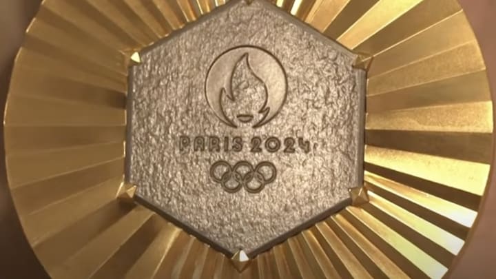 Paris 2024 gold medal featuring a piece of the Eiffel Tower. 