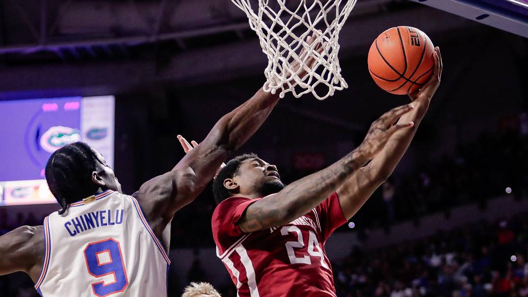 Feb 28, 2026; Gainesville, Florida, USA; Arkansas Razorbacks wing Billy Richmond III (24) goes up for a layup against Florida Gators center Rueben Chinyelu (9) during the first half at Exactech Arena at the Stephen C. O'Connell Center. Mandatory Credit: Travis Register-Imagn Images