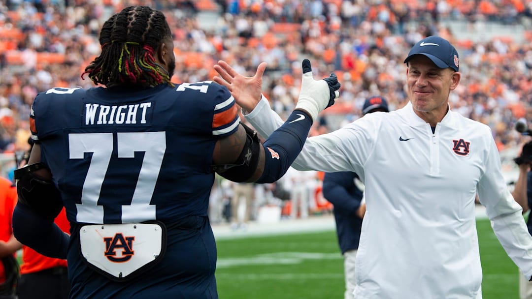 Auburn Tigers interim head coach DJ Durkin hugs offensive lineman Jeremiah Wright (77)