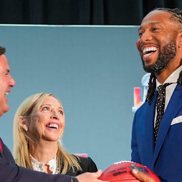 Doug Ducey, governor of Arizona, left, hands off a football to Larry Fitzgerald, former Cardinals wide receiver and executive chairperson of the Arizona Super Bowl host committee, right, as Jay Parry, Arizona Super Bowl Host Committee CEO, center, smiles during the official Super Bowl Host Committee handoff press conference at the Los Angeles Convention Center on Monday, Feb. 14, 2022, in Los Angeles.

Sbhostcomm 02142022 At 011