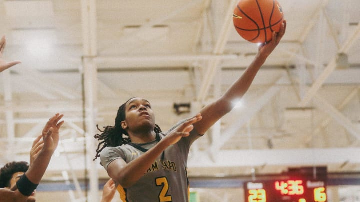 Team Thad’s Jasper Johnson (2) lays the ball up against Team Oak Soldiers’ Doug Langford (13) during the Nike Elite Youth Basketball League