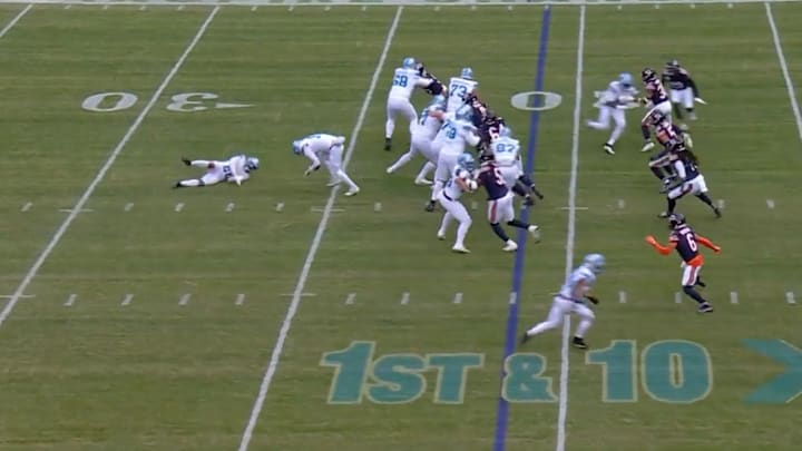 Jared Goff and Jahmyr Gibbs fall down as part of a play fake.