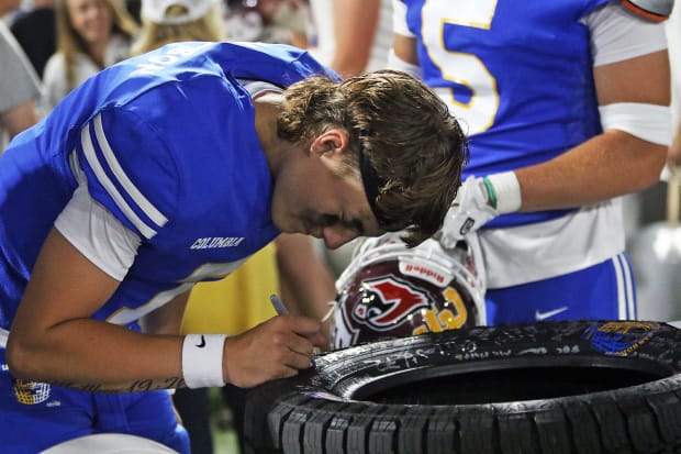 Zayden Anderson of Seaside signs a tire after the 2024 Les Schwab Bowl in Portland, Oregon. (Photo by Dan Brood) 