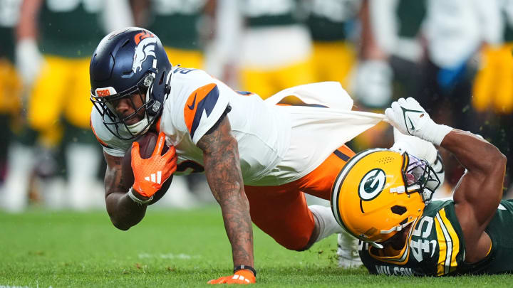 Aug 18, 2024; Denver, Colorado, USA; Green Bay Packers linebacker Eric Wilson (45) tackles Denver Broncos wide receiver Tim Patrick (12) in the first quarter at Empower Field at Mile High. 