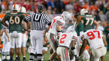 Ohio State's Mike Doss (2) leads teammates Dustin Fox (37) and Kenny Peterson (97) in a prayer after Miami's Willis McGahee was injured in the fourth quarter of the National College Football Championship at Sun Devil Stadium in Tempe, Arizona, January 3, 2003.
