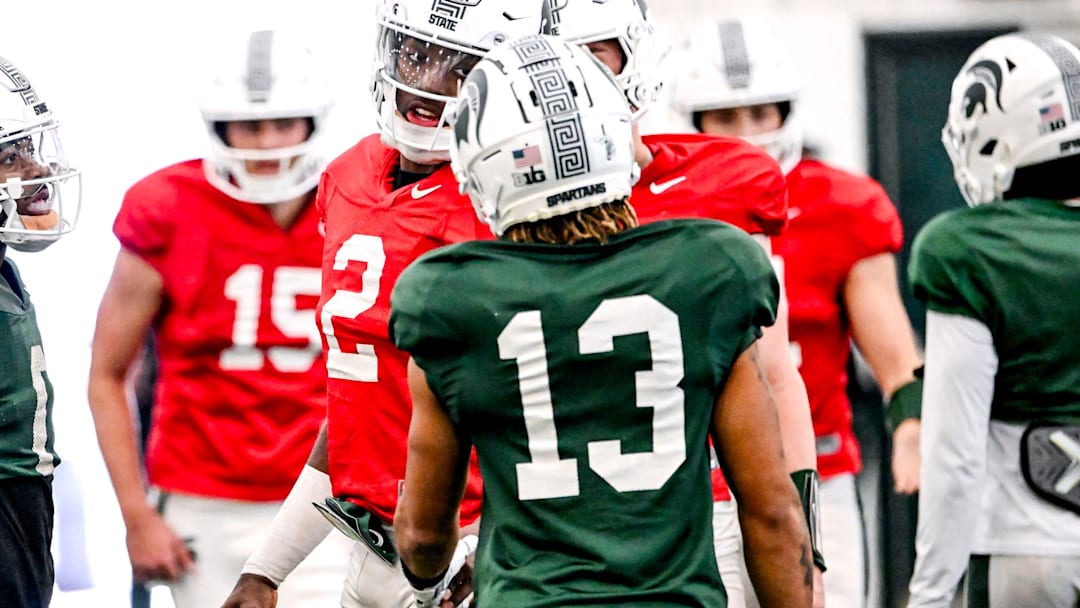 Michigan State quarterback Aidan Chiles, center, talks with receivers Chrishon McCray, right, and Nick Marsh during football practice on Tuesday, April 8, 2025, in East Lansing.