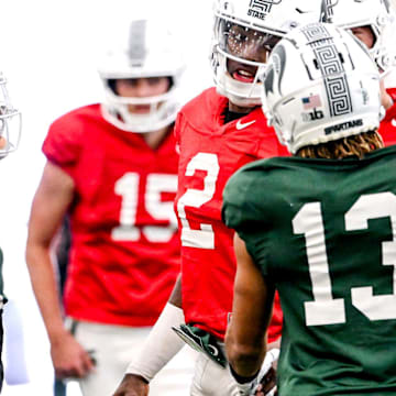 Michigan State quarterback Aidan Chiles, center, talks with receivers Chrishon McCray, right, and Nick Marsh during football practice on Tuesday, April 8, 2025, in East Lansing.