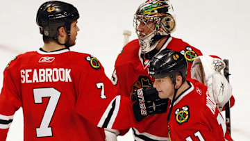 Mar 5, 2010; Chicago, IL, USA; Chicago Blackhawks goalie Cristobal Huet (top right) is congratulated by teammates Brent Seabrook (7) and John Madden (11) after defeating teh Vancouver Canucks 6-3 at the United Center. Mandatory Credit: Jerry Lai-Imagn Images