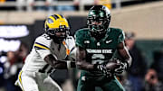 Michigan defensive back Zeke Berry (10) tackles Michigan State wide receiver Nick Marsh (6) during the first half at Spartan Stadium in East Lansing on Saturday, October 25, 2025.