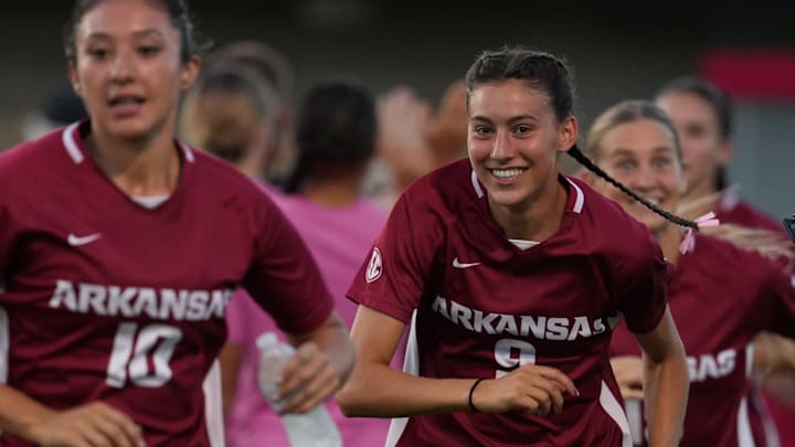 Arkansas freshmen Camila Palacios (10) and Madison Rose (9) run out on the field ahead of a match.
