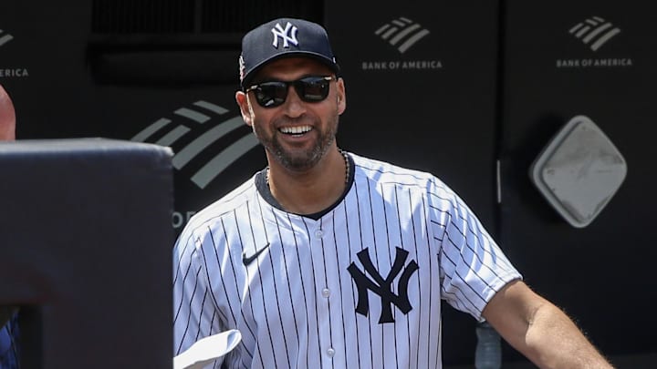 Former New York Yankees star Derek Jeter stands in the dugout.