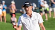 Collin Morikawa acknowledges fans after making a birdie putt on the 18th.