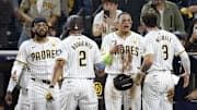Oct 8, 2024; San Diego, California, USA; San Diego Padres second baseman Xander Bogaerts (2) and outfielder Jackson Merrill (3) celebrate with outfielder Fernando Tatis Jr. (23), left, and third baseman Manny Machado (13) after scoring in the second inning against the Los Angeles Dodgers during game three of the NLDS for the 2024 MLB Playoffs at Petco Park. 
