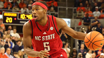 Dec 3, 2025; Auburn, Alabama, USA;  NC State Wolfpack guard Tre Holloman (5) runs a play as Auburn Tigers guard Kaden Magwood (5) defends during the first half at Neville Arena. Mandatory Credit: John Reed-Imagn Images