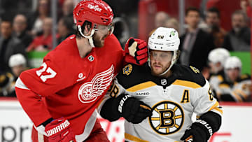 Mar 29, 2025; Detroit, Michigan, USA; Boston Bruins right wing David Pastrnak (88) collides with Detroit Red Wings center in the second period at Little Caesars Arena. Mandatory Credit: Lon Horwedel-Imagn Images