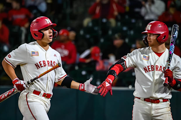 Will Jesske (left) high fives Max Buettenback (right) after scoring on a Minnesota throwing error. 