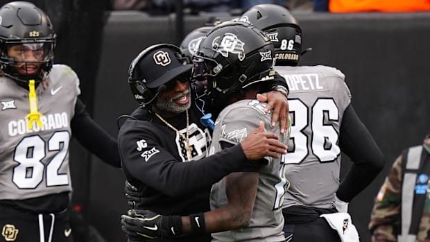 Colorado Buffaloes head coach Deion Sanders hugs wide receiver Travis Hunter (12) following a touchdown in the fourth quarter