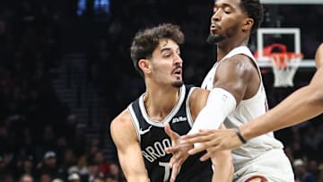 Oct 24, 2025; Brooklyn, New York, USA;  Brooklyn Nets guard Ben Saraf (77) is double teammed by Cleveland Cavaliers guard Donovan Mitchell (45) and center Jarrett Allen (31) in the first quarter at Barclays Center. Mandatory Credit: Wendell Cruz-Imagn Images