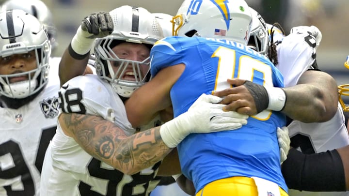 Sep 8, 2024; Inglewood, California, USA;Los Angeles Chargers quarterback Justin Herbert (10) is sacked by Las Vegas Raiders defensive end Maxx Crosby (98) in the first half at SoFi Stadium. Mandatory Credit: Jayne Kamin-Oncea-Imagn Images