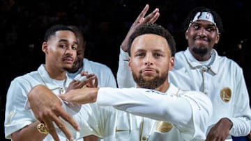 October 18, 2022; San Francisco, California, USA; Golden State Warriors guard Jordan Poole (left, 3), guard Stephen Curry (center, 30), and center Kevon Looney (right, 5) celebrate with their championship rings before the game against the Los Angeles Lakers at Chase Center. Mandatory Credit: Kyle Terada-Imagn Images