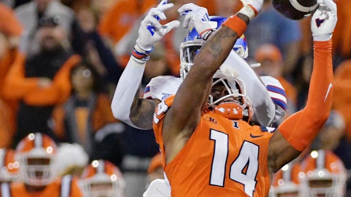 Sep 7, 2024; Champaign, Illinois, USA; Illinois Fighting Illini defensive back Xavier Scott (14) intercepts the ball in front of Kansas Jayhawks wide receiver Quentin Skinner (0) during the first half at Memorial Stadium. Mandatory Credit: Ron Johnson-Imagn Images