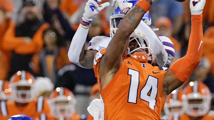 Sep 7, 2024; Champaign, Illinois, USA; Illinois Fighting Illini defensive back Xavier Scott (14) intercepts the ball in front of Kansas Jayhawks wide receiver Quentin Skinner (0) during the first half at Memorial Stadium. Mandatory Credit: Ron Johnson-Imagn Images