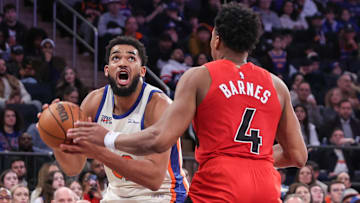 Nov 30, 2025; New York, New York, USA;  New York Knicks center Karl-Anthony Towns (32) looks to drive past Toronto Raptors forward Scottie Barnes (4) in the fourth quarter at Madison Square Garden. Mandatory Credit: Wendell Cruz-Imagn Images