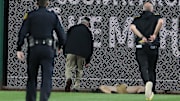 Stadium security and Pittsburgh Pirates medical personnel rush to assist a fan who fell from the stands to the field as the Pirates batted against the Chicago Cubs during the seventh inning at PNC Park. 