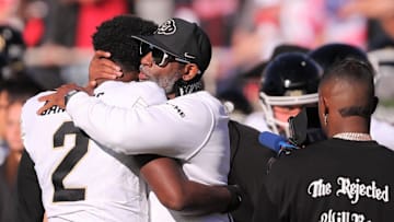 Colorado football coach Deion Sanders hugs his son, Shedeur Sanders, before facing Texas Tech.