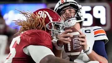 Nov 30, 2024; Tuscaloosa, Alabama, USA; Alabama Crimson Tide defensive lineman Tim Keenan III (96) hits Auburn quarterback Payton Thorne (1) and takes him down for a loss during the Iron Bowl game between Alabama and Auburn at Bryant-Denny Stadium. Alabama defeated Auburn 28-14. Mandatory Credit: Gary Cosby Jr.-Imagn Images