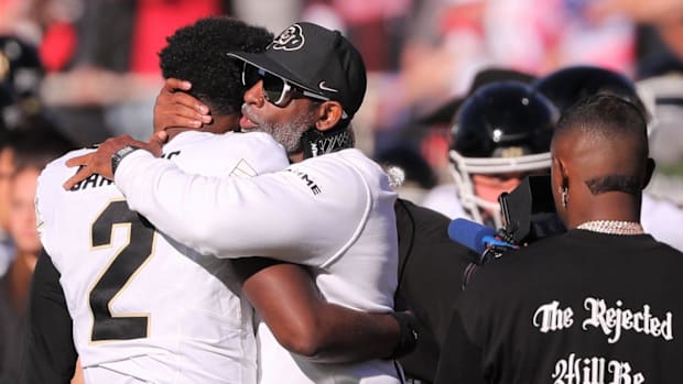 Colorado football coach Deion Sanders hugs his son, Shedeur Sanders, before facing Texas Tech in a Big 12 football game Satur