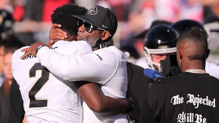 Colorado football coach Deion Sanders hugs his son, Shedeur Sanders, before facing Texas Tech.