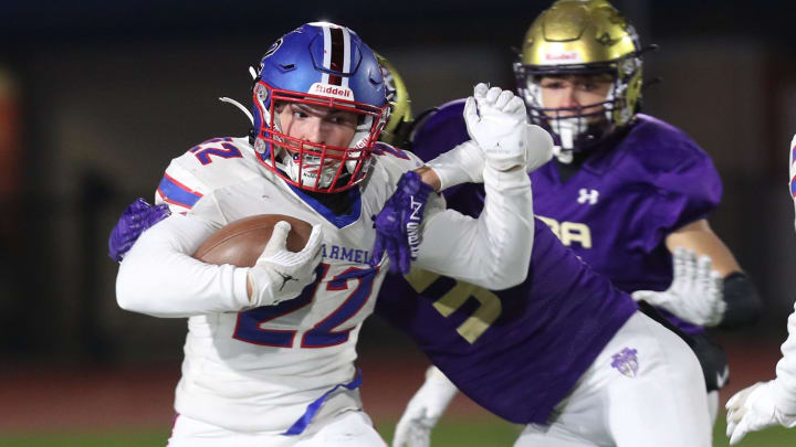 Carmel's Tristan Werlau (22) runs back a kick-off for a first half touchdown against Christian Brothers Academy during the Class AA state semifinal playoff game at Middletown High School Nov. 25, 2023.