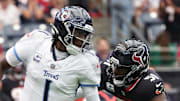 Tennessee Titans quarterback Cam Ward scrambles from Houston Texans defensive end Will Anderson Jr.