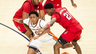 Auburn Tigers guard Tahaad Pettiford (0) draws a foul from NC State Wolfpack guard Terrance Arceneaux (21) as Auburn Tigers take on NC State Wolfpack at Neville Arena in Auburn, Ala. on Wednesday, Dec. 3, 2025. Auburn Tigers lead NC State Wolfpack 41-35 at halftime.