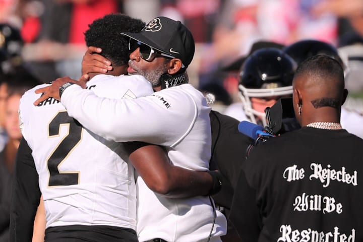 Colorado football coach Deion Sanders hugs his son, Shedeur Sanders, before facing Texas Tech.