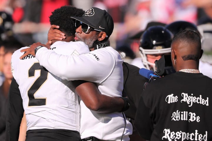Colorado football coach Deion Sanders hugs his son, Shedeur Sanders, before facing Texas Tech.