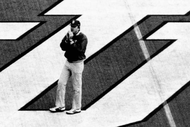 Indiana football coach Sam Wyche stands on the field at Memorial Stadium in 1983.