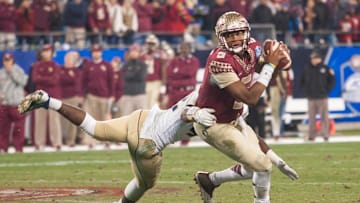 Dec 6, 2014; Charlotte, NC, USA; Florida State Seminoles quarterback Jameis Winston (5) tries to avoid the pressure by Georgia Tech Yellow Jackets defensive end KeShun Freeman (42) during the third quarter at Bank of America Stadium. FSU defeated Georgia Tech 37-35. Mandatory Credit: Jeremy Brevard-Imagn Images