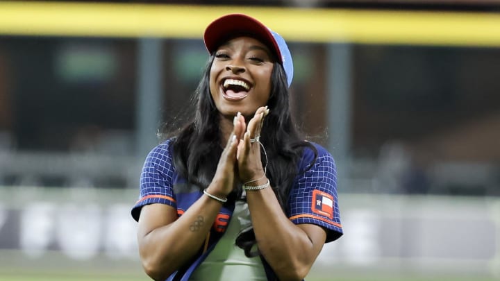 Aug 30, 2024; Houston, Texas, USA; Simone Biles, Paris Summer Olympics 2024 gymnast gold medal winner, reacts after throwing out the ceremonial first pitch.  Olympian teammate and gold medalist , Jordan Chiles, and the Houston area Olympians were also in attendance before the Kansas City Royals played against the Houston Astros at  Minute Maid Park. 