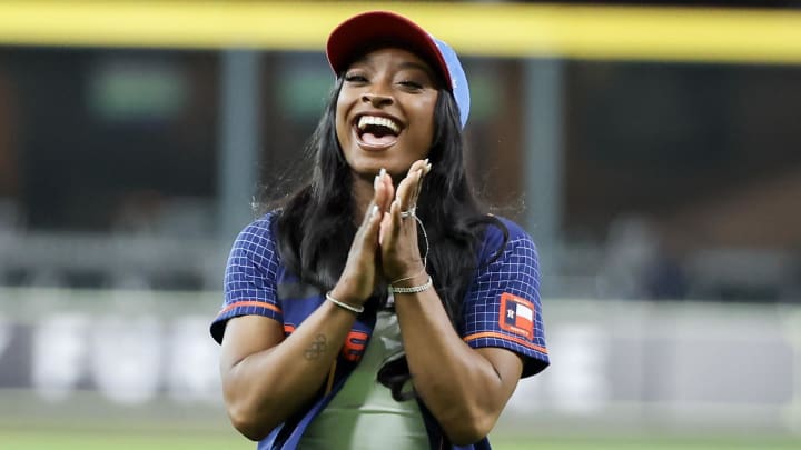 Simone Biles reacts after throwing out the ceremonial first pitch ahead of the Astros' game against the Royals.