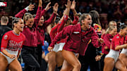 The Arkansas gymnastics team storms the floor after knocking off No. 2 Florida at Bud Walton Arena on Feb. 7, 2025.