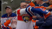 A fan at Game 5 of the Stanley Cup Final takes off his Oilers jersey to reveal a Panthers jersey.